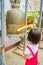 AYUTTHAYA, THAILAND, FEBRUARY, 08, 2018: Outdoor view of unidentified little girl knocking the sacred bell inside of a