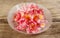 Azalea flowers in glass bowl on wooden background.