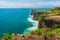 Azure beach with rocky mountains and clear water of Indian ocean at sunny day / A view of a cliff in Bali Indonesia