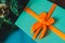 Azure gift box with an orange bow close up