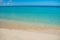 Azure turquoise calm sea, clear blue sky, sandy beach and flat horizon