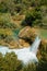 An azure waterfall surrounded by emerald greenery