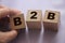 B2B abbreviation in letters on wooden cubes. Business to Busness concept Hand put a cube B to the row. Business marketing strategy