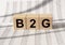 B2G text on Wooden Blocks Representing Business 2 Government model, financial documents