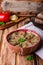 Babaganoush with tomatoes, cucumber and parsley - arabian eggplant dish or salad on wooden background. Selective focus