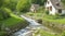 A babbling brook winding its way through a peaceful village.