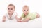Babies girl and boy lying on a white background and holding hand