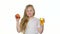 Babies girl drinks juice from a glass and holds an apple. White background