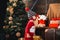 Babies. Happy small kids in santa hat with present have a christmas. Portrait kid with gift on wooden background. Winter