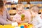 Babies learning fruits playing toys with teacher in nursery