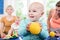 Babies with pacifier in toddler group playing with toys