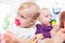 Babies with pacifier in toddler group playing with toys