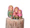 Babushka dolls arranged on wood log.