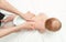 The baby is 5 months old, lying on his tummy. Mom gives back massage to the child, for its development. Children`s gymnastics and