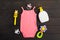 Baby accessories - pink bodysuit, soap, pacifier and rattle over wooden background