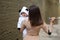Baby in the arms of mom in a panda costume. A young girl with child in city.