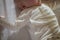 The baby is on the back and touches the toy. White body suit on newborn. Comfortable clothes for newborn. child stuck out his