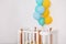 Baby bedroom interior. Minimalistic baby room interior. Festive balloons in front of baby bed. Baby birthday celebration concept.