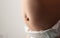 Baby belly with bulging navel on a gray background. Umbilical hernia in newborns, dilated umbilical ring, medical. Copy