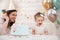 Baby birthday party. Mother and her daughter celebrate and fun together. Child party with balloons decoration and cake