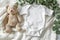 Baby bodysuit mockup with teddy bear, eucalyptus on ivory blanket throw infant onesie template