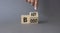 Baby boost symbol. Businessman hand points at turned wooden cubes with words Boost and Baby. Beautiful grey background. Business