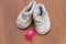 Baby booties and soother on wooden background