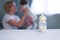 Baby bottle with breast milk for breastfeeding at foreground and mother with baby at background, mothers breast milk is