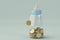 Baby bottles bank and gold coin on blue background. 3d illustration