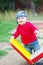 Baby boy age of 10 months stands by teeter-totter