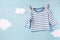 Baby boy clothes and cute white clouds on a clothesline, blue background