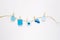 Baby boy concept. Blue decor and toys are hung on rope on white background. Newborn accessories. Children`s background