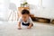 Baby boy crawling on the floor in living room indoors. Toddler Asian family at home