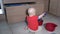 Baby boy doing mess in kitchen. Child play with bowls and utensil