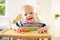 Baby Boy Eating Fruit In High Chair