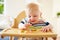 Baby Boy Eating Fruit In High Chair