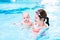 Baby boy enjoying swimming lesson in pool with mother