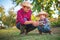 Baby boy farmer, little chicken in his hands and proud woman grandmother outdoor in farmland. Farm animals and happy family in the