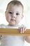 Baby boy girl with white looks out of the crib down. Portrait of a child close-up. Soft focus. Cute baby brown eyes