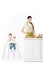 baby boy in highchair with toy and mother cutting zucchini at table