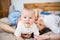 A baby boy at home on bed with unrecognizable parents.