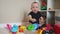 Baby boy play in kindergarten. Baby child play toys cubes and cars on the table in kindergarten. Happy family preschool