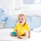 Baby boy playing on bed in sunny nursery