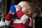 Baby boy playing with bottle and mug indoor