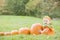 Baby boy in pumpkin costume with pumkins