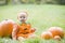 Baby boy in pumpkin costume with pumpkins