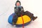 Baby boy rolling in the snowy slide on a tubing. Cheerful handsome boy riding a roller coaster.