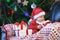 Baby boy in Santas clothes holding Christmas present