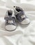 Baby boy shoes on white satin background, vertical view, copy space