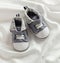 Baby boy shoes on white satin background, vertical view, copy space